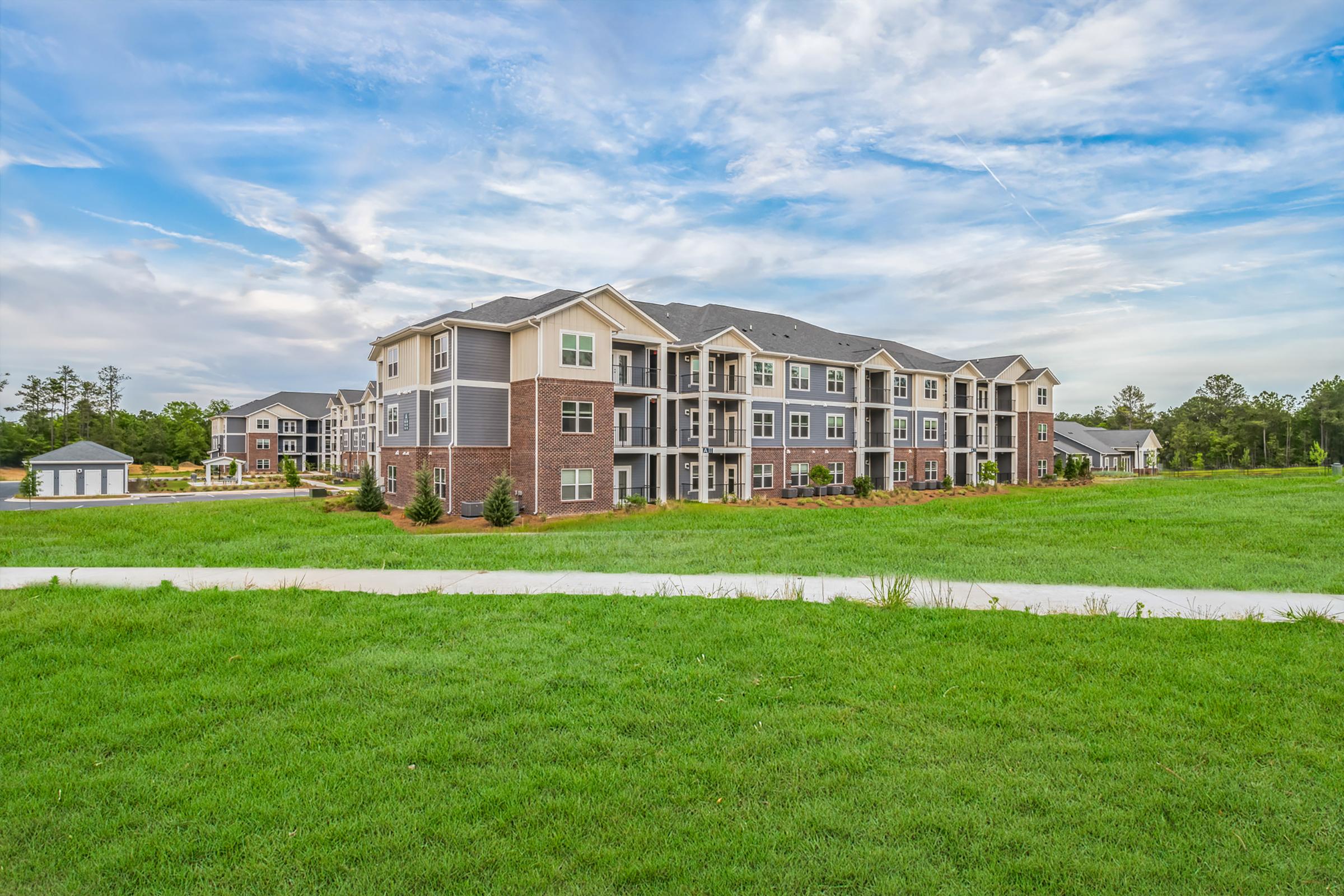 a large green field in front of a house