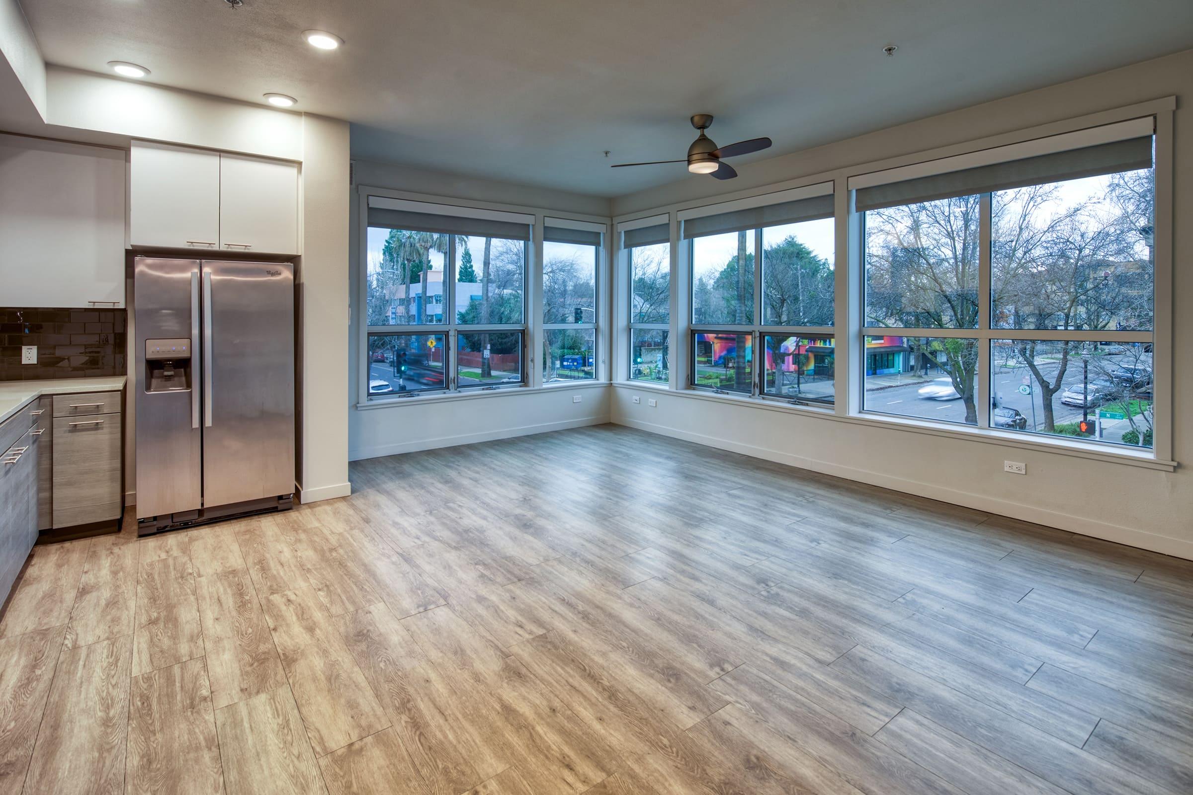 kitchen area with wood style vinyl plank flooring refrigerator and windows with a view. 