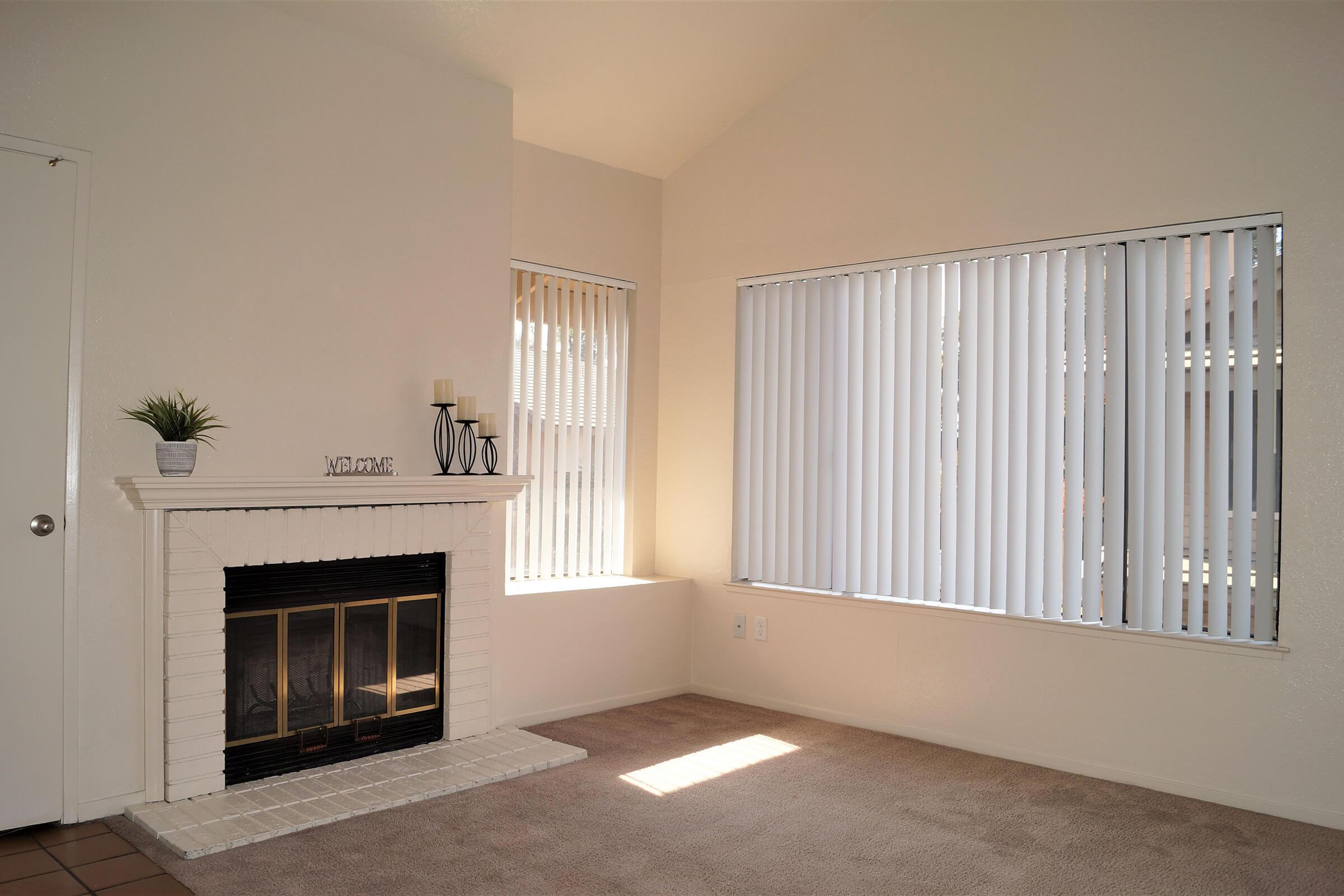 a living room with a fireplace and a large window