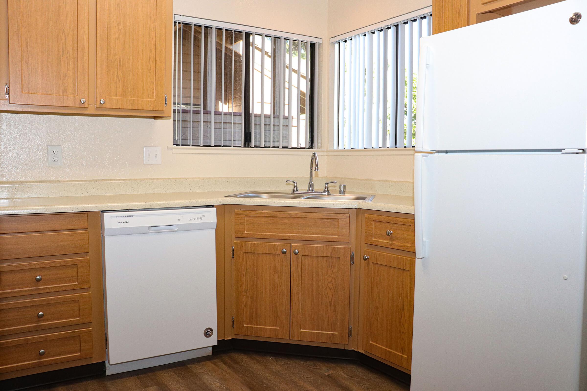 a kitchen with a stove refrigerator and wooden cabinets