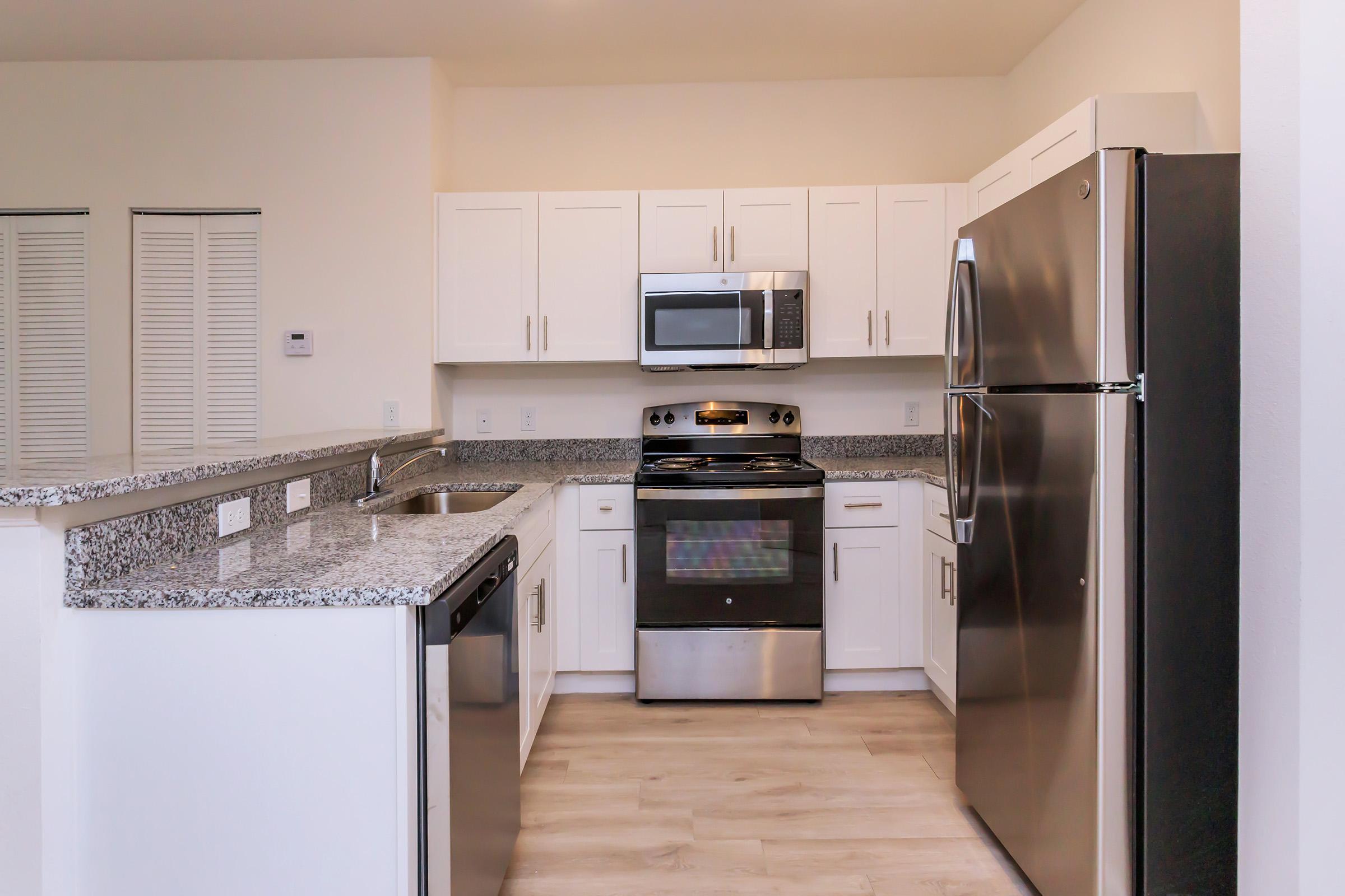 a modern kitchen with stainless steel appliances and wooden cabinets