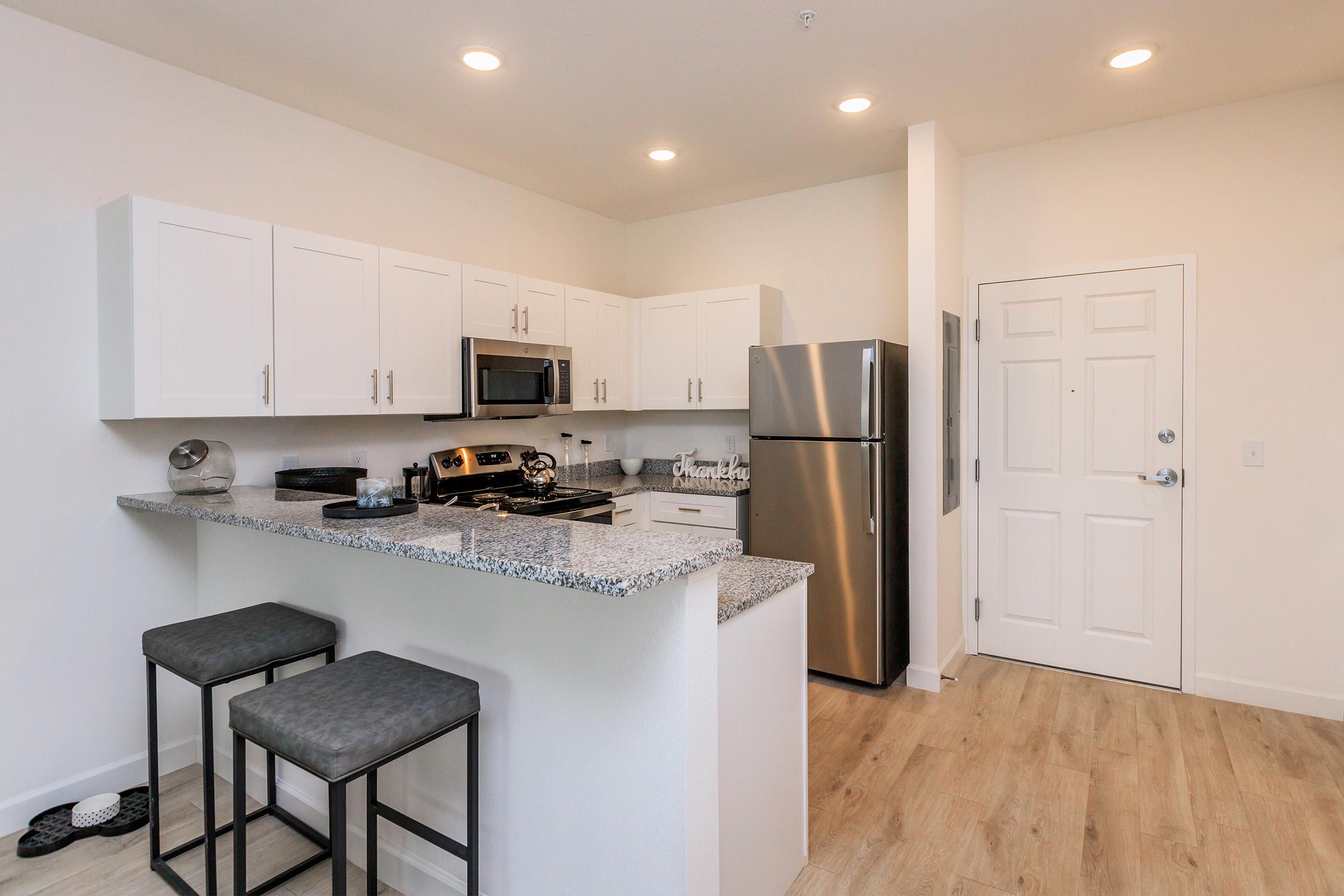 a kitchen with a stainless steel refrigerator in a room