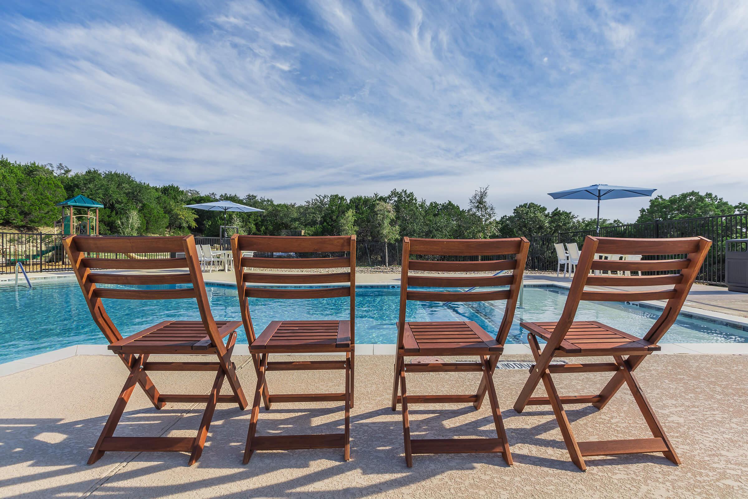 a group of lawn chairs sitting on top of a sandy beach