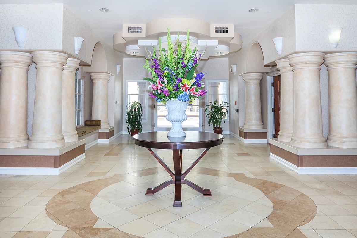 a room filled with furniture and vase of flowers on a table