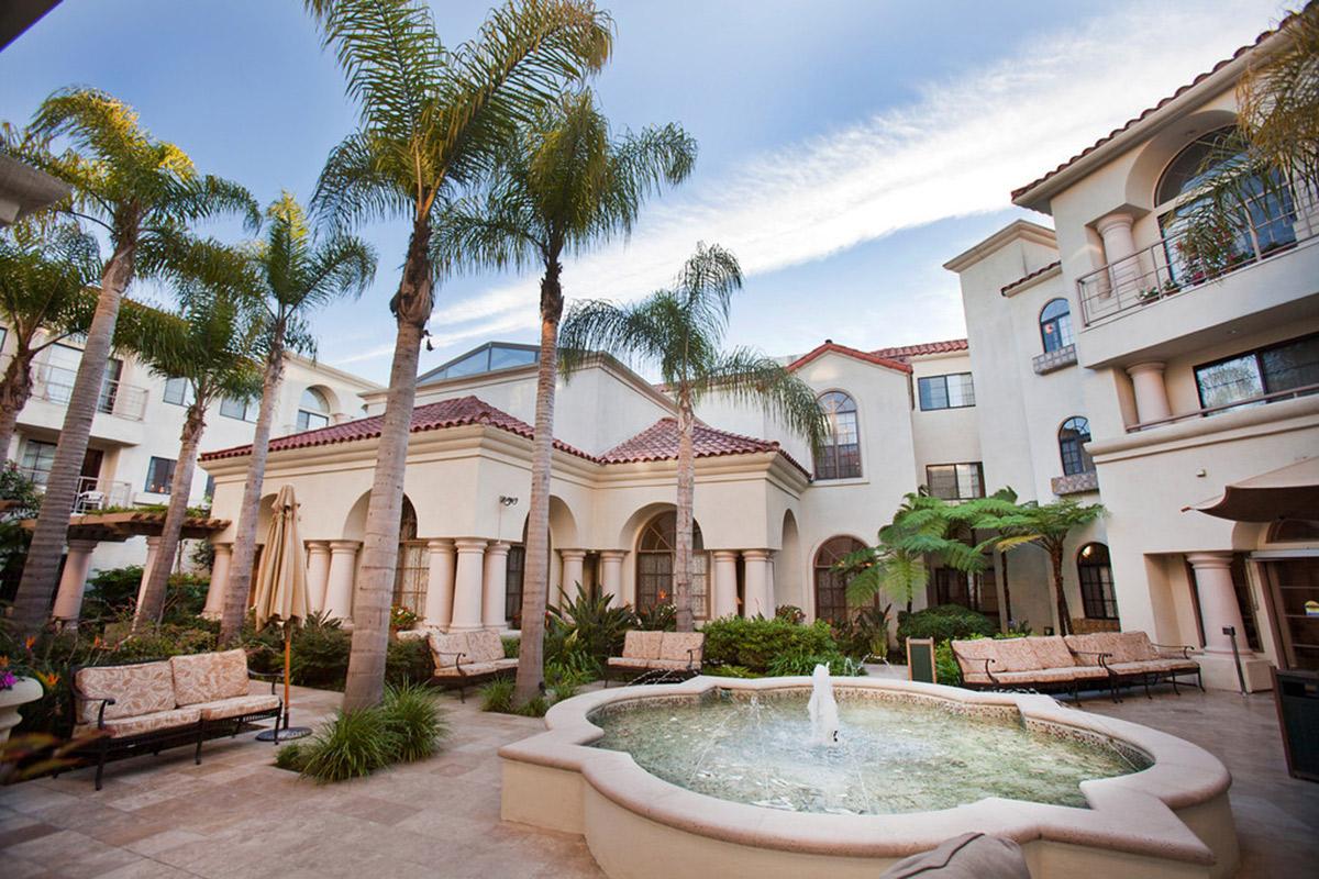 a large stone building with palm trees