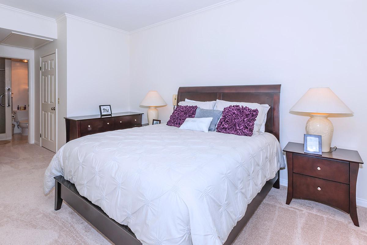 a bedroom with a bed and desk in a hotel room