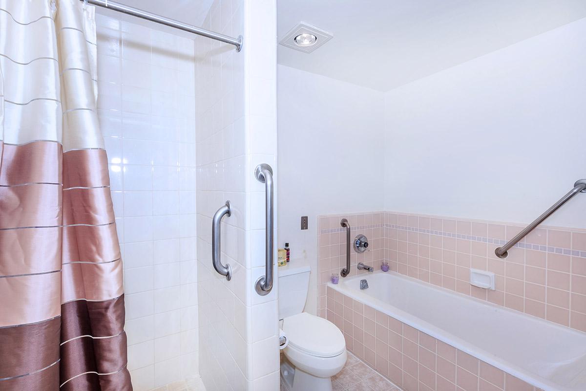 a white sink sitting next to a shower