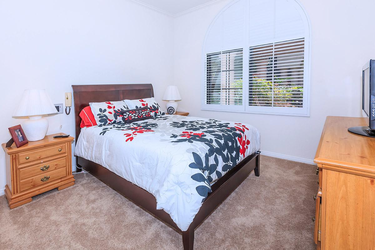 a bedroom with a bed and desk in a room