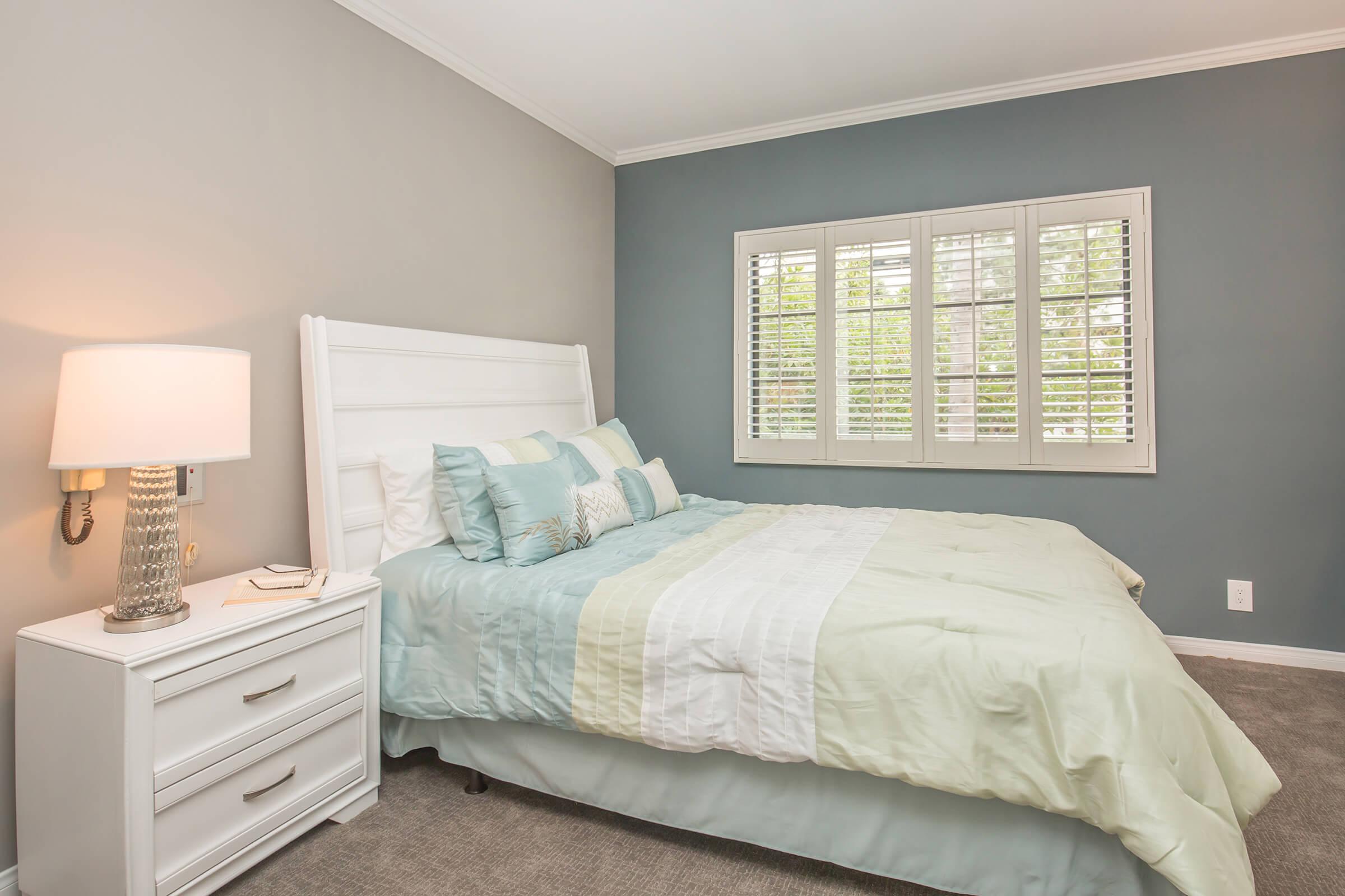 a bedroom with a bed and desk in a room