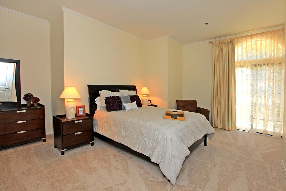 a bedroom with a bed and desk in a hotel room