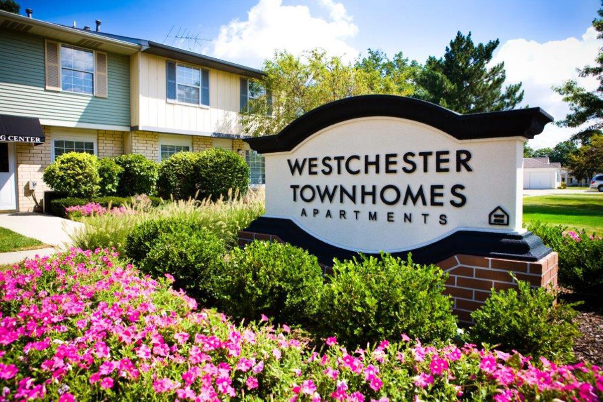 a close up of a flower garden in front of a house