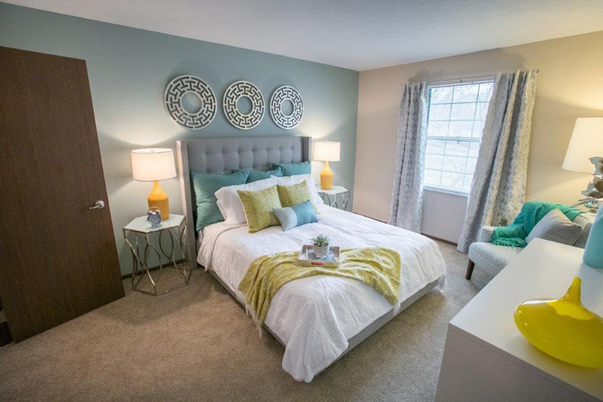 a bedroom with a bed and desk in a room