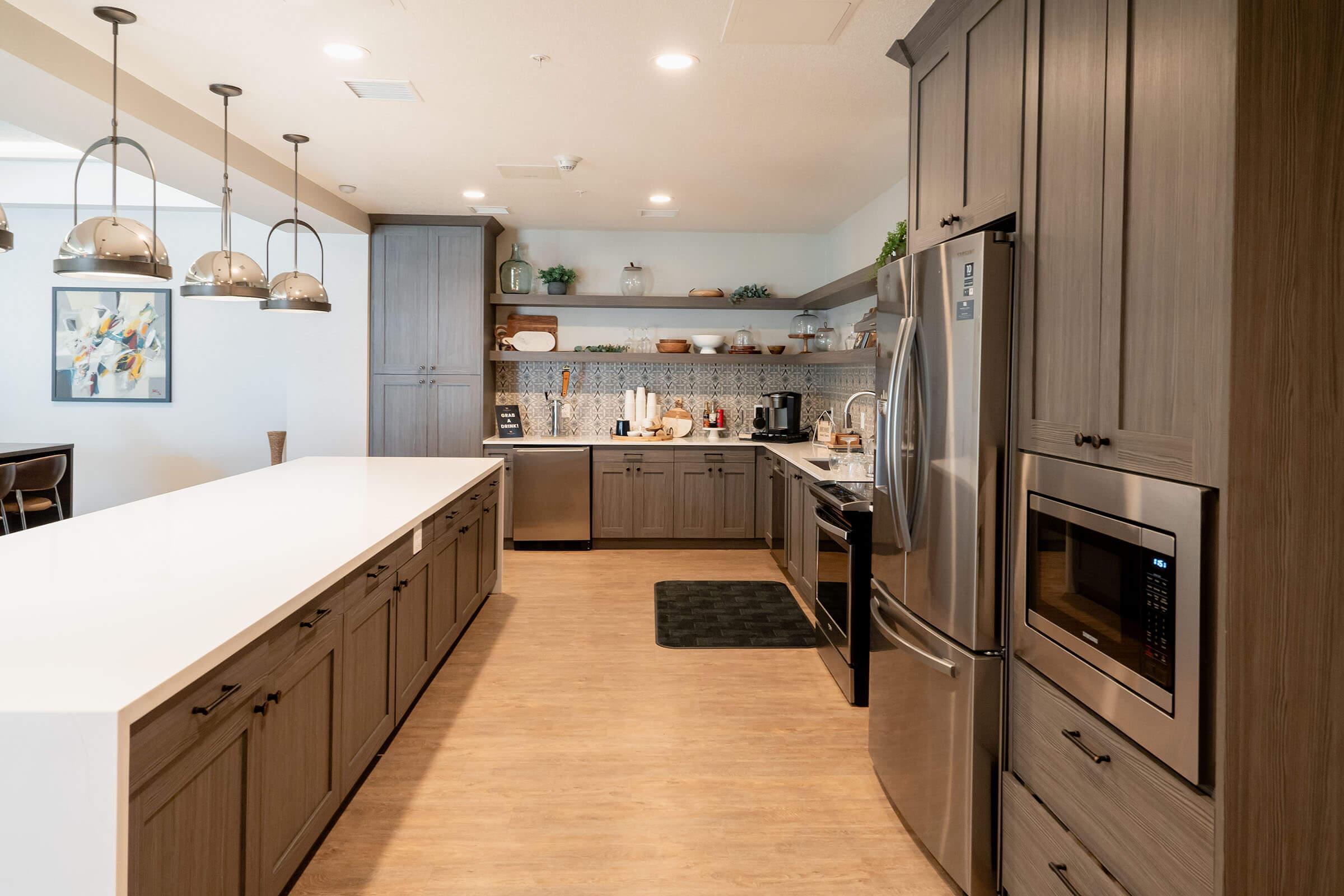 a large kitchen with stainless steel appliances and wooden cabinets