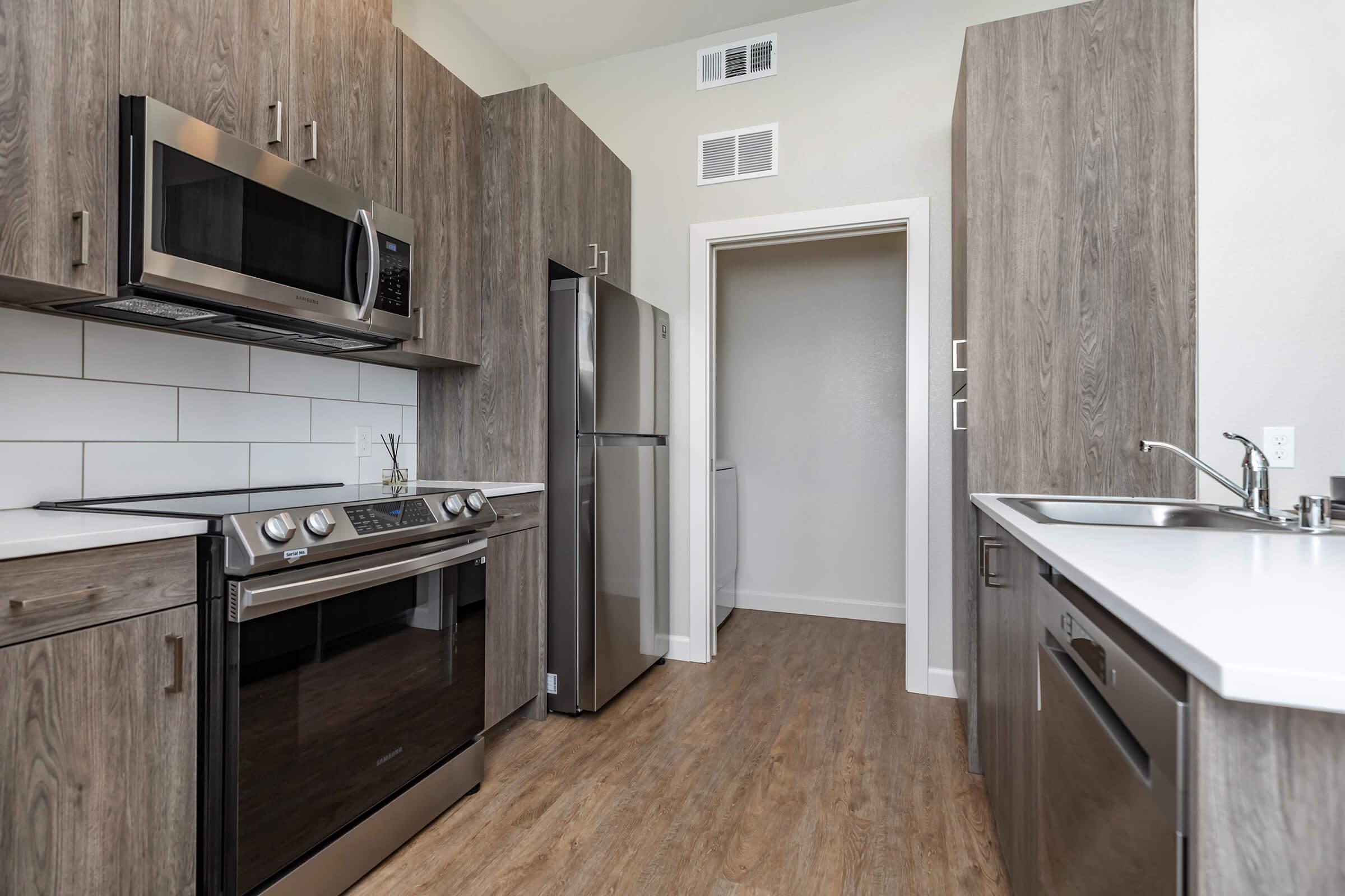 a large kitchen with stainless steel appliances and wooden cabinets