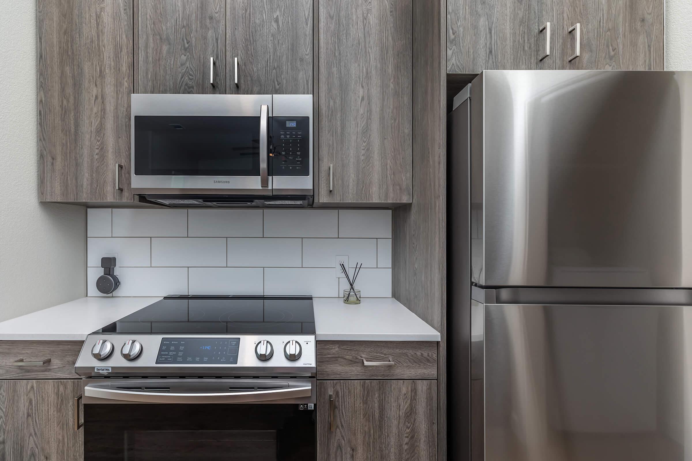 a kitchen with a stove a microwave oven sitting on top of a refrigerator