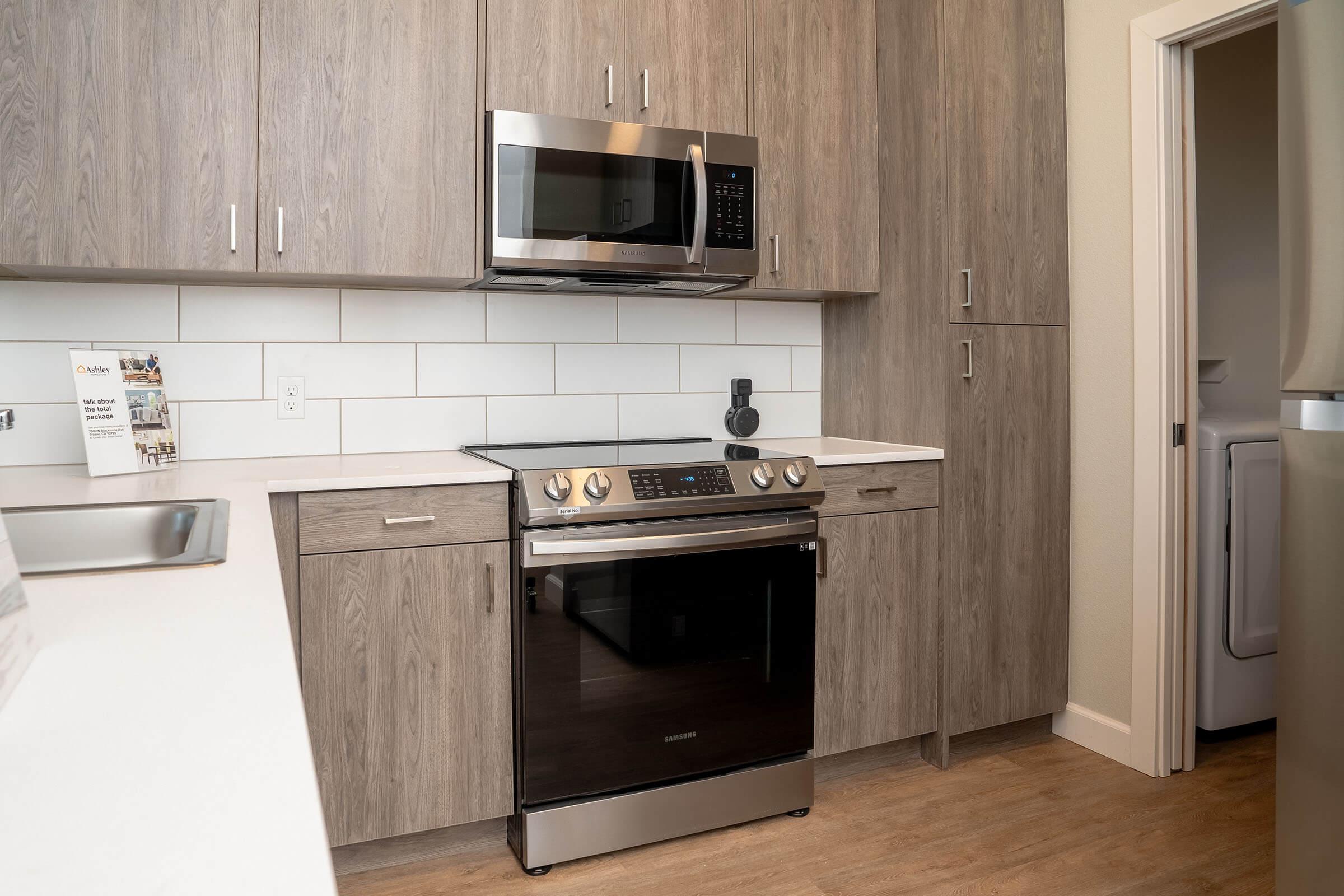 a stove top oven sitting inside of a kitchen with stainless steel appliances