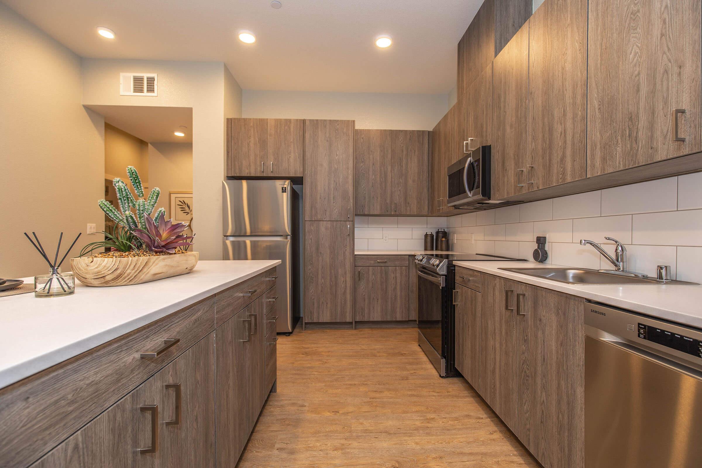 a large kitchen with stainless steel appliances and wooden cabinets