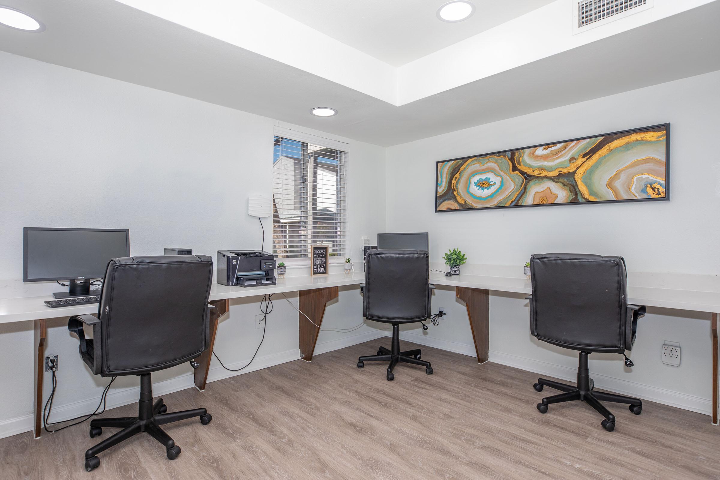 a living area with a desk and chair in a room