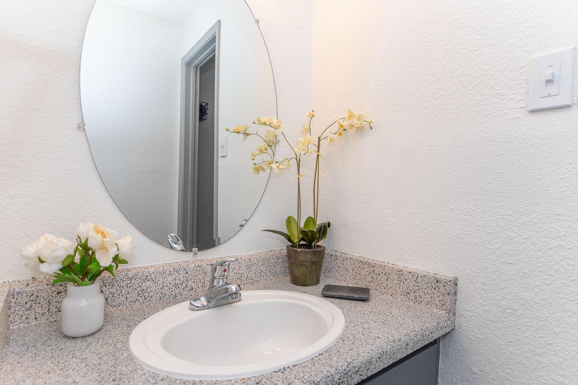 a vase of flowers on a table next to a sink