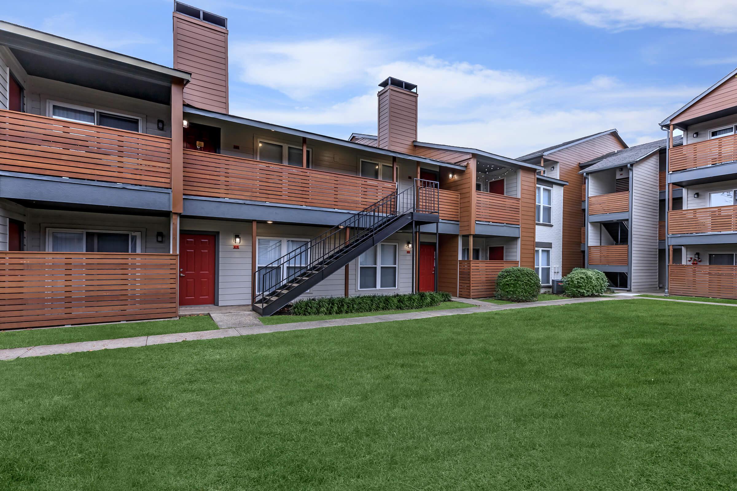 a large lawn in front of a brick building