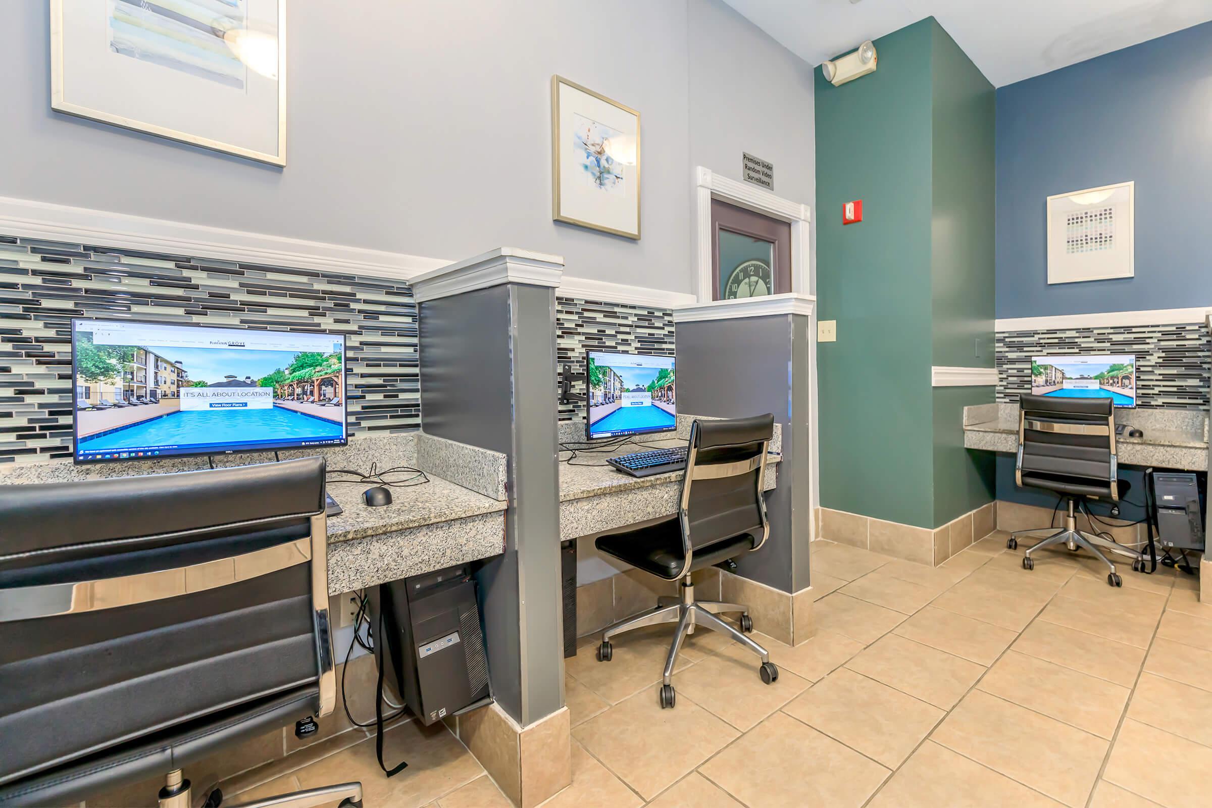 a desk with a computer and a chair in a room