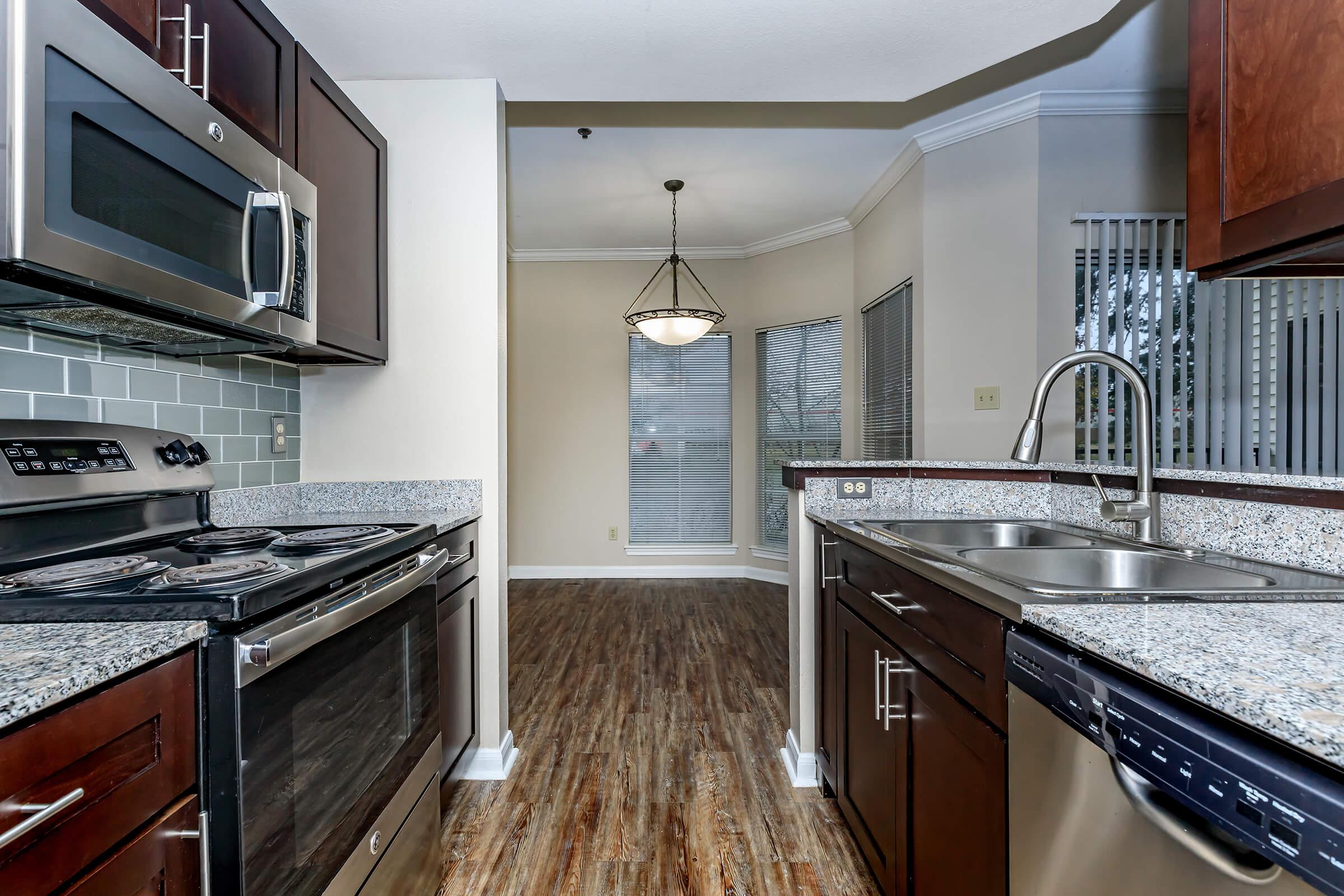 a large kitchen with stainless steel appliances and wooden cabinets