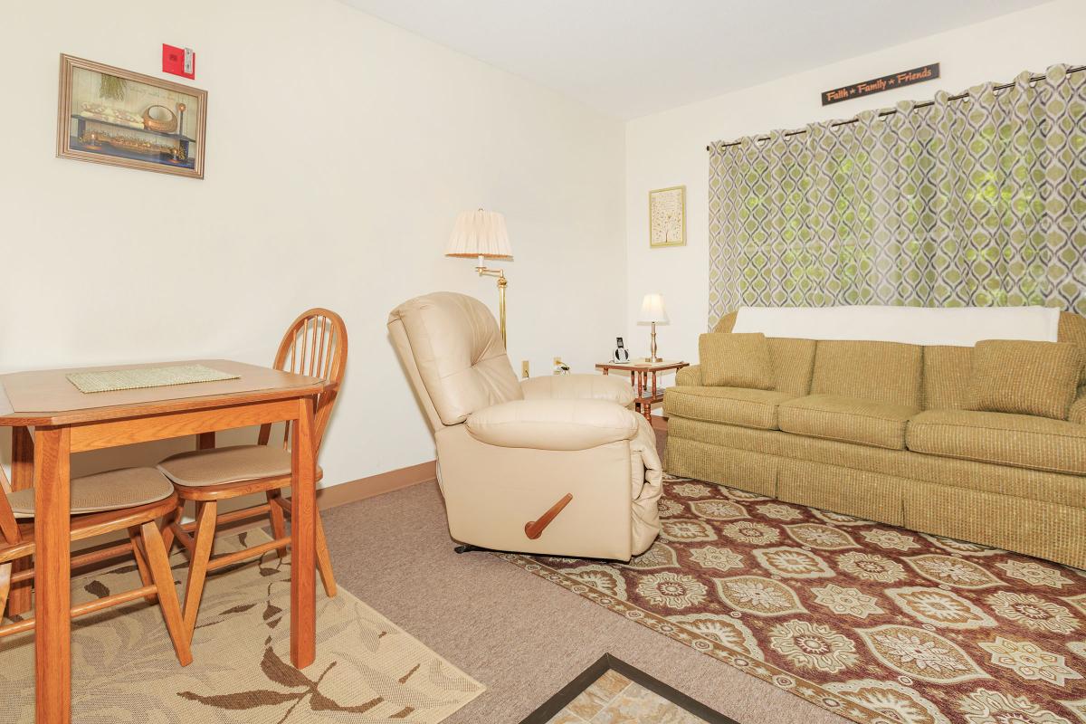 a bedroom with a bed and a chair in a room