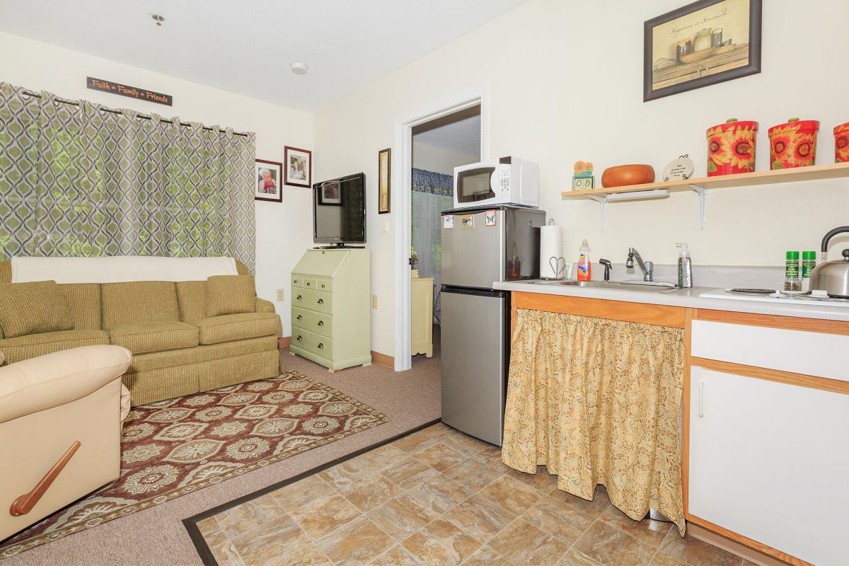 a living room filled with furniture and a refrigerator