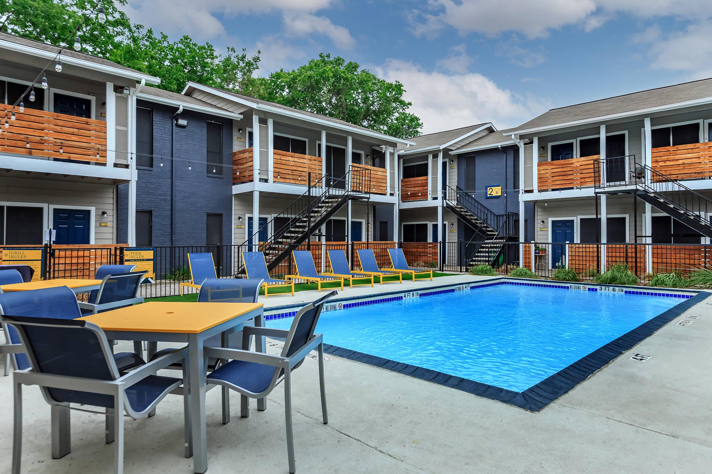 a group of lawn chairs sitting on a chair in front of a pool