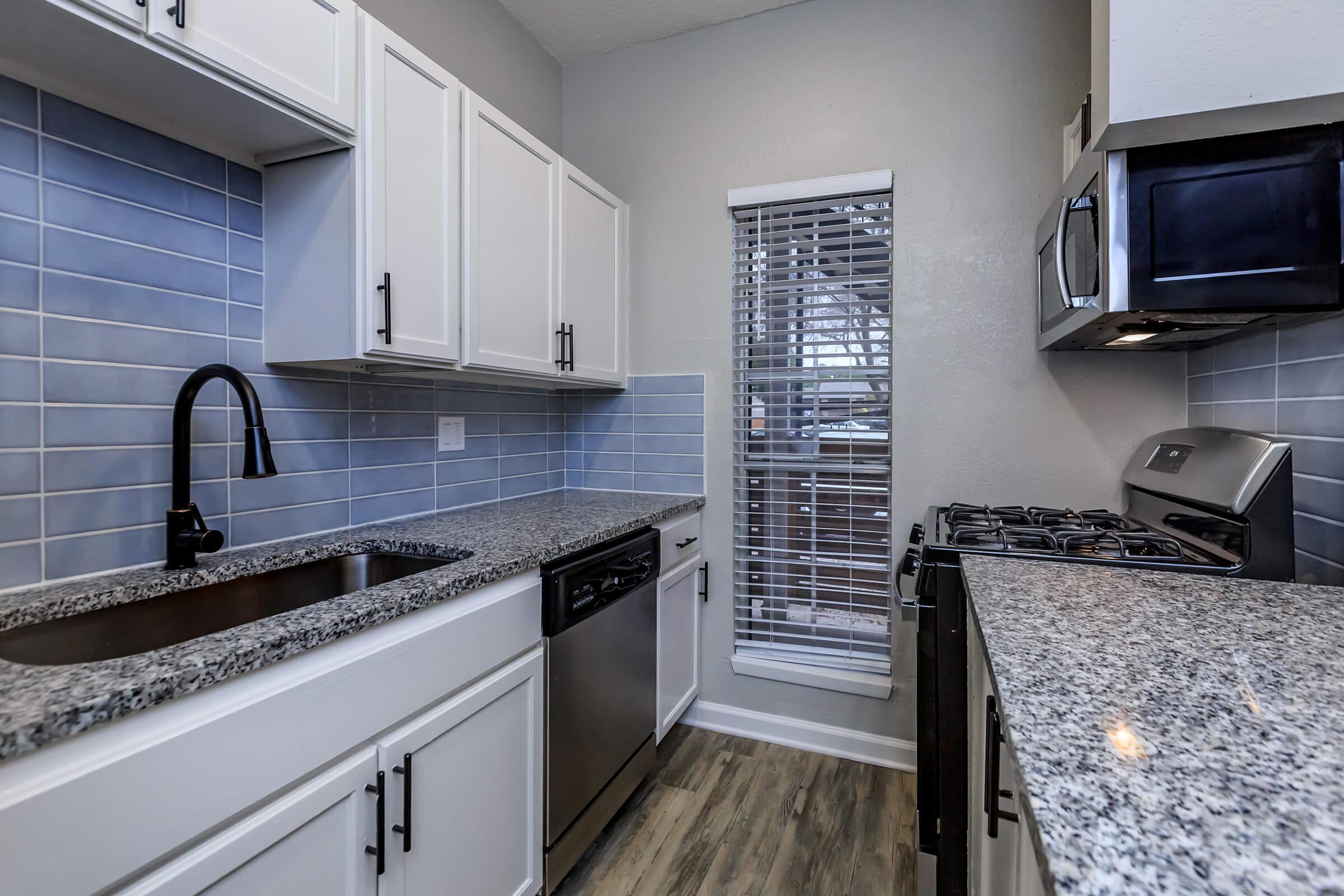 a kitchen with a stove a sink and a window