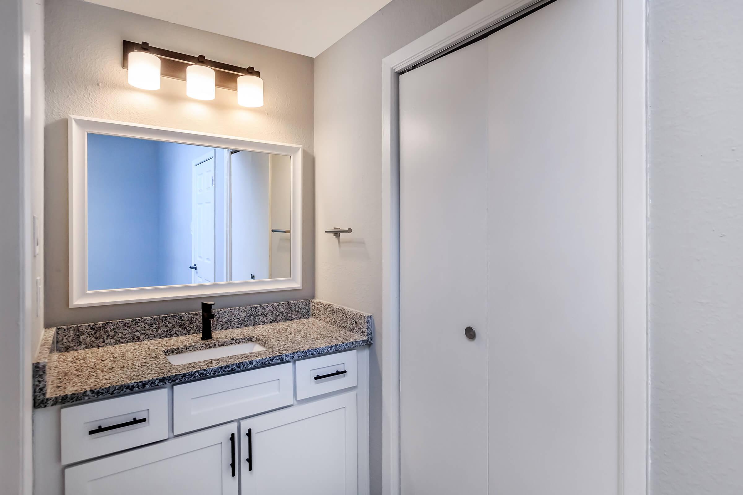 a kitchen with a sink and a mirror