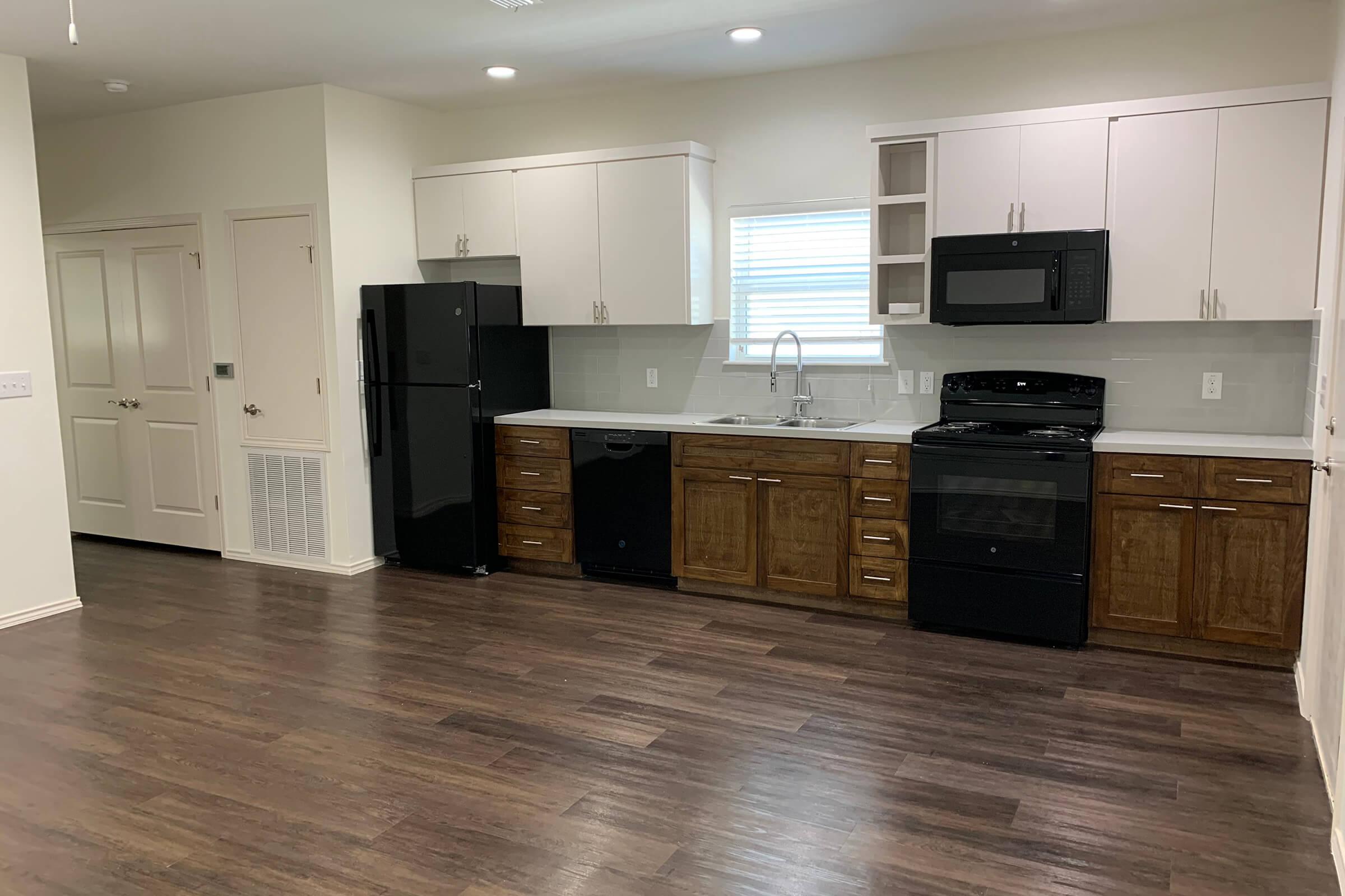 a large kitchen with stainless steel appliances and wooden cabinets