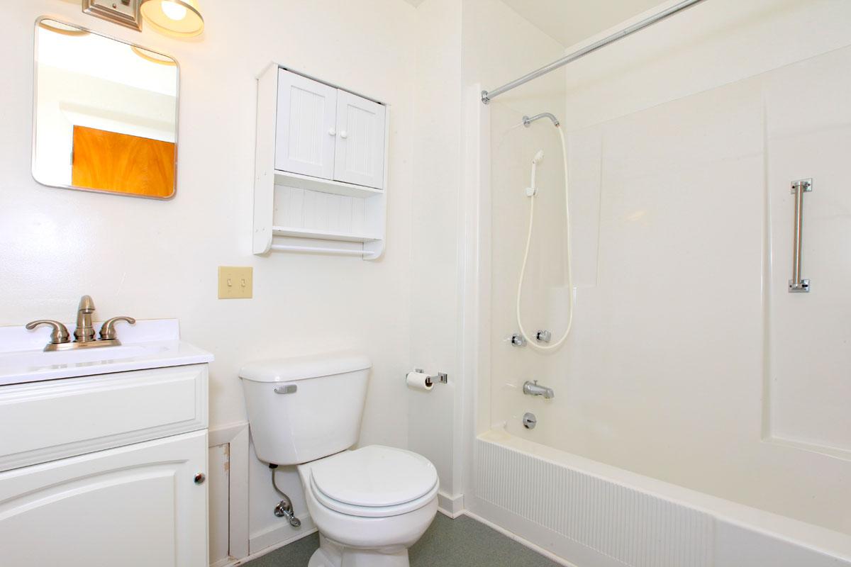 a white sink sitting next to a shower