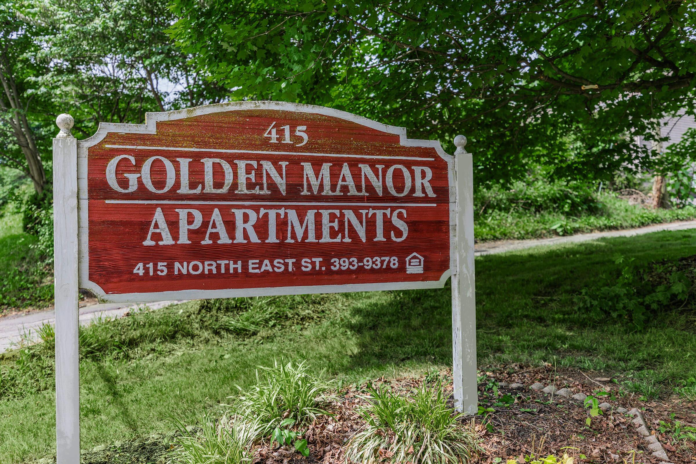 a sign over a grassy area