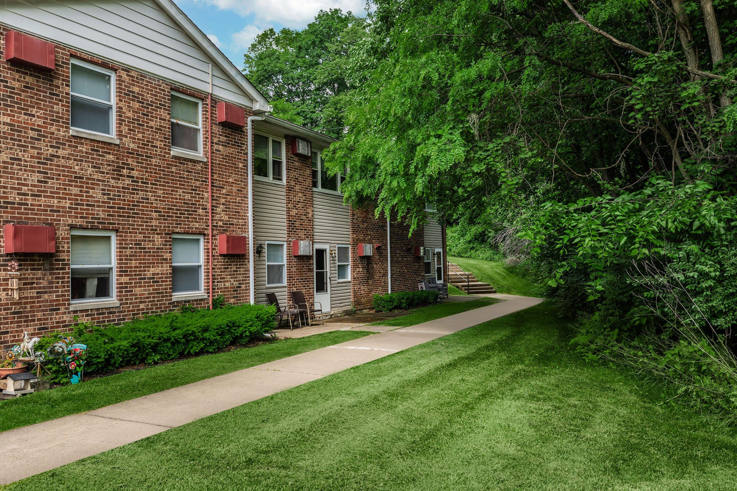 a large brick building with grass in front of a house