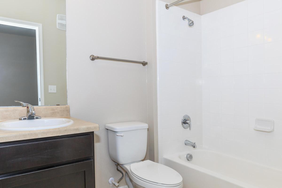 a white sink sitting under a mirror