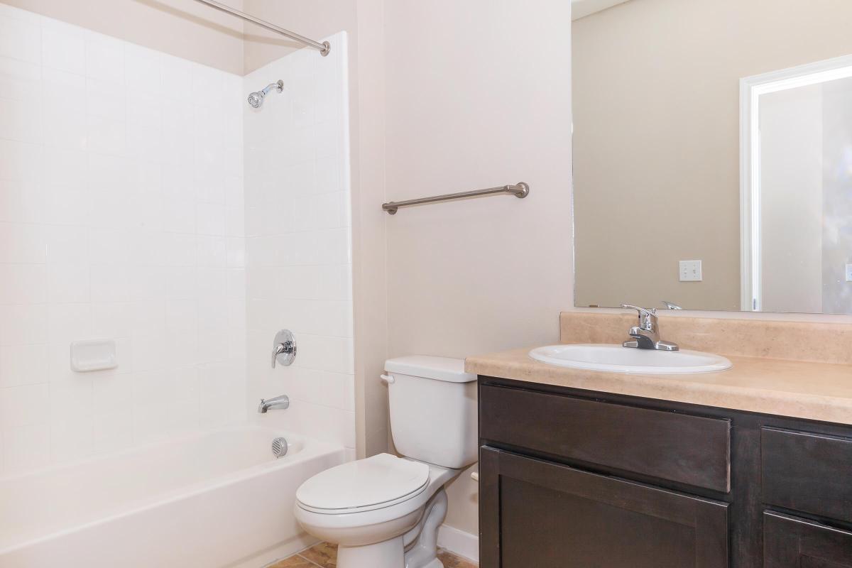 a white sink sitting next to a shower