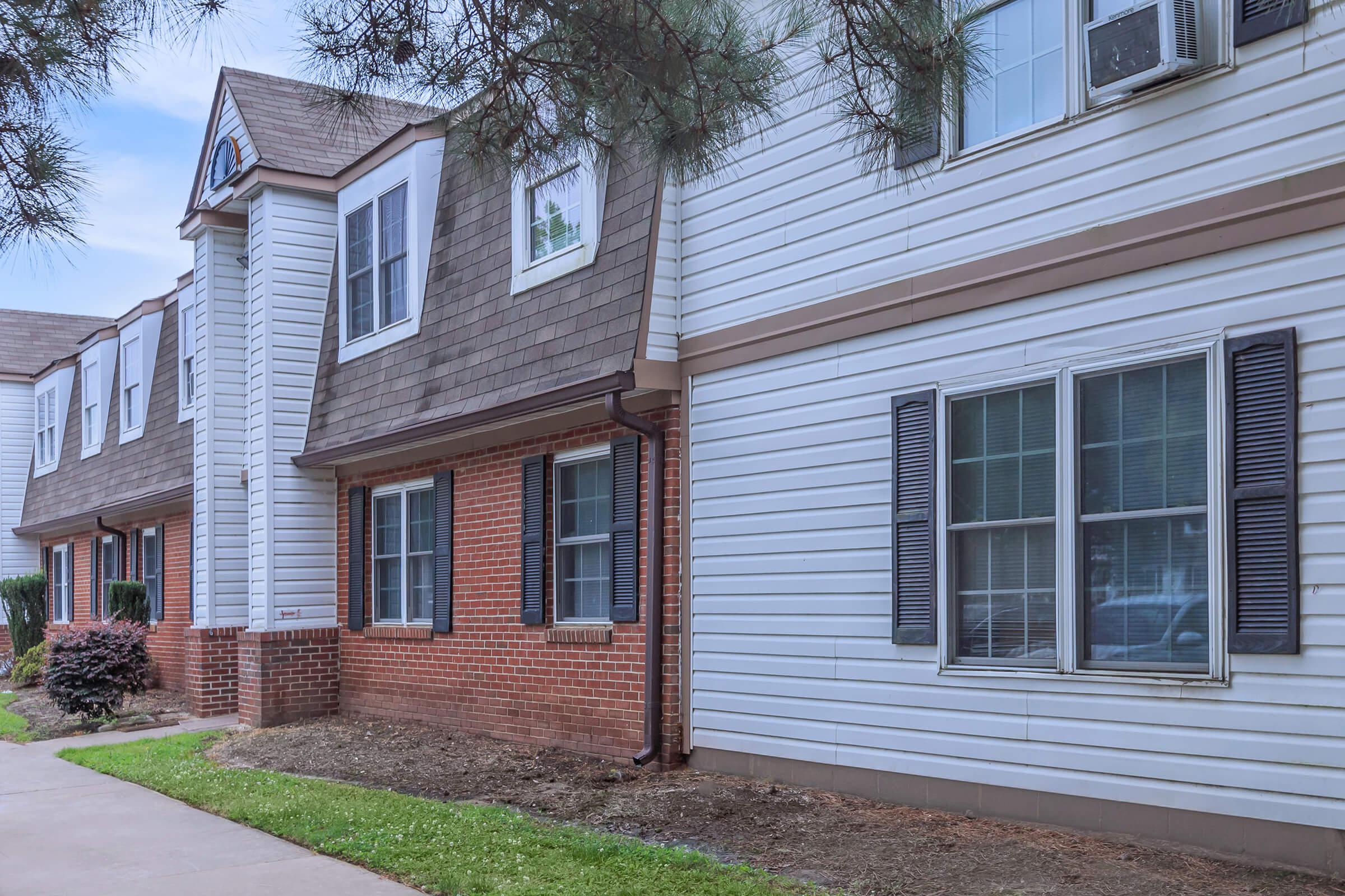 a large brick building with grass in front of a house