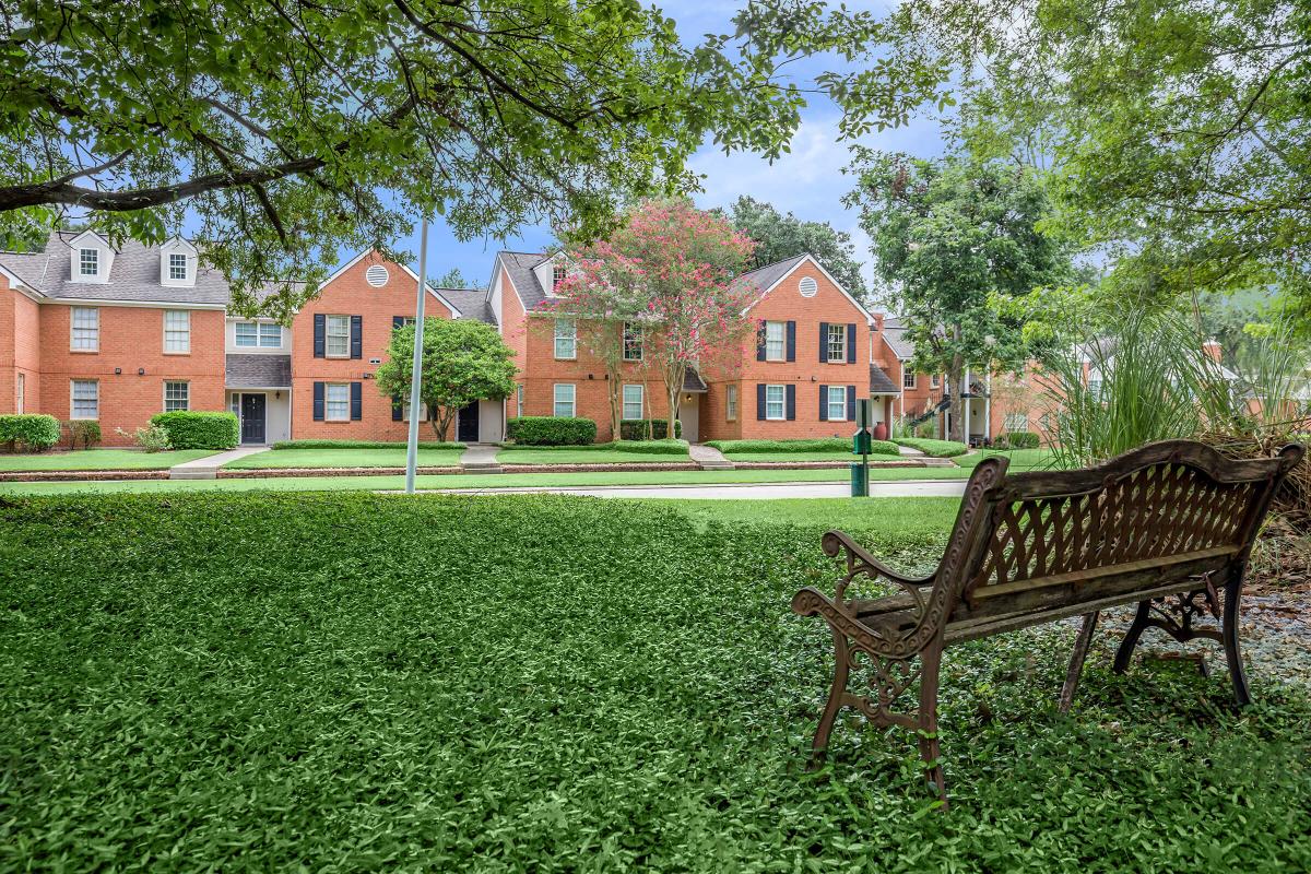 a couple of lawn chairs sitting on a bench in front of a house