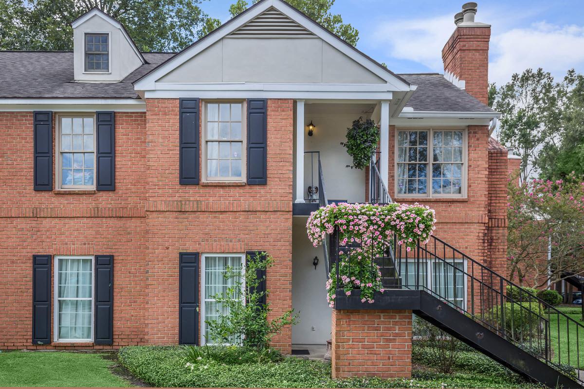 a large brick building with grass in front of a house