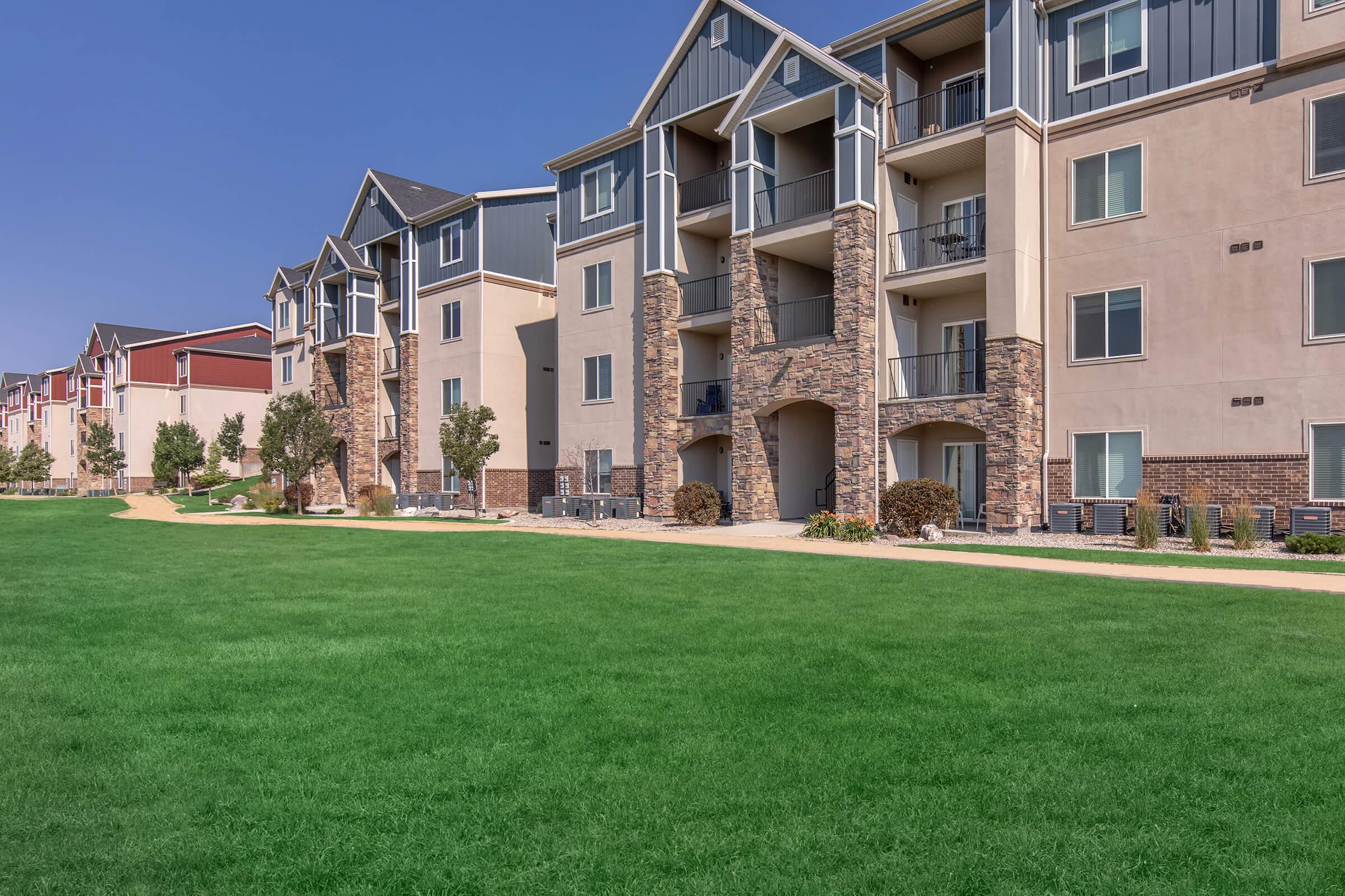 a large green field in front of a building