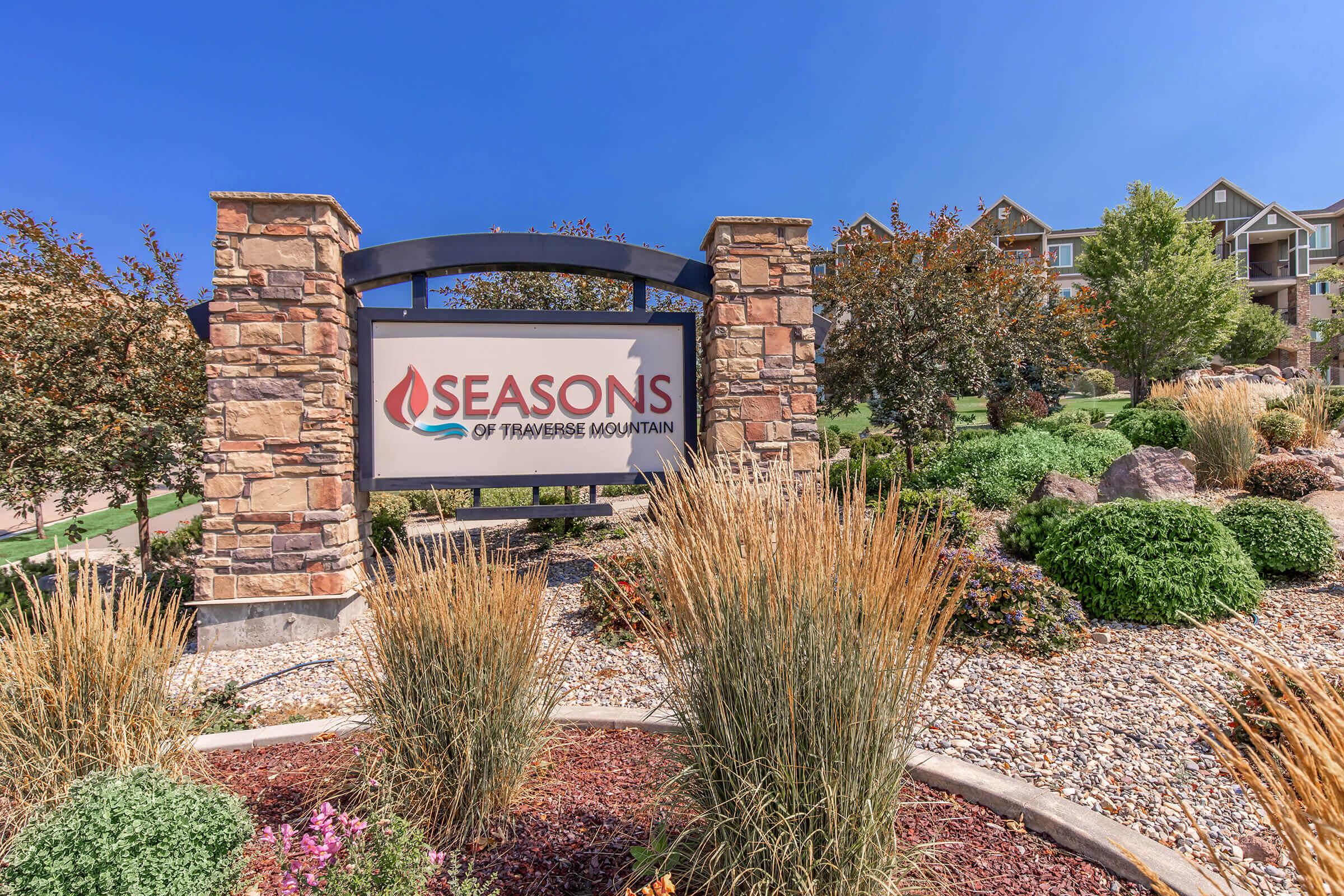 a group of bushes in front of a brick building