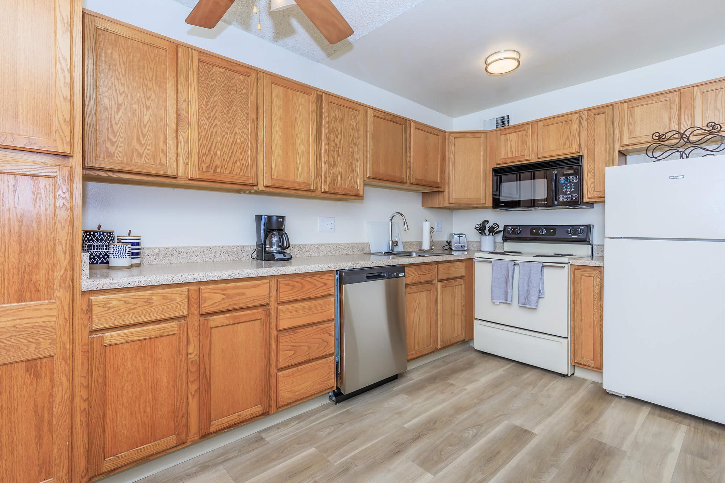 a kitchen with wooden cabinets and a wood floor