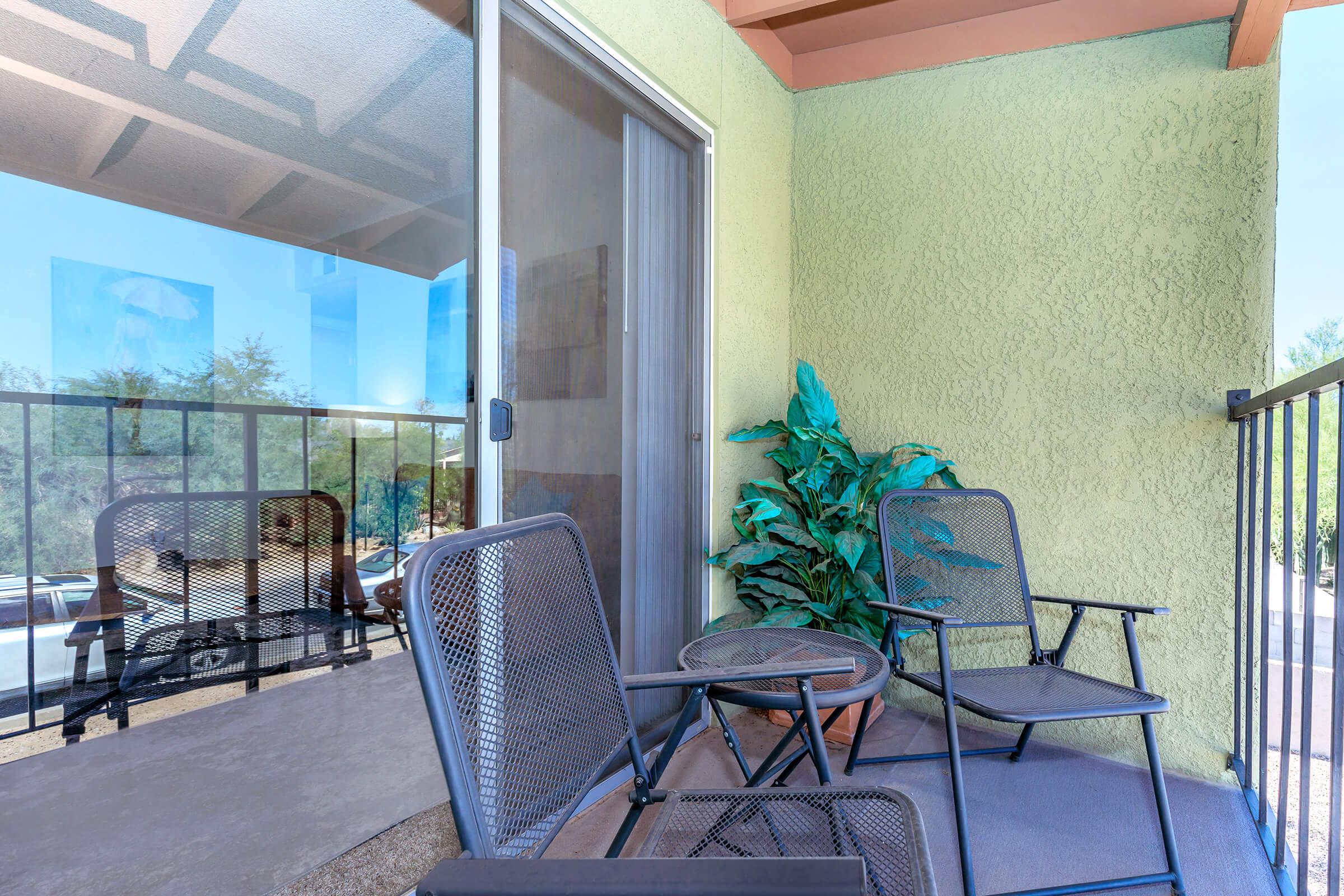 a glass with a blue chair next to a fence