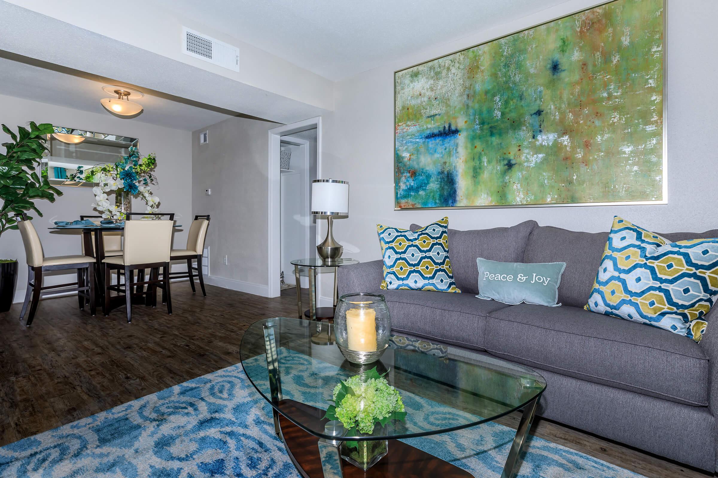 a living room filled with furniture and vase of flowers on a table