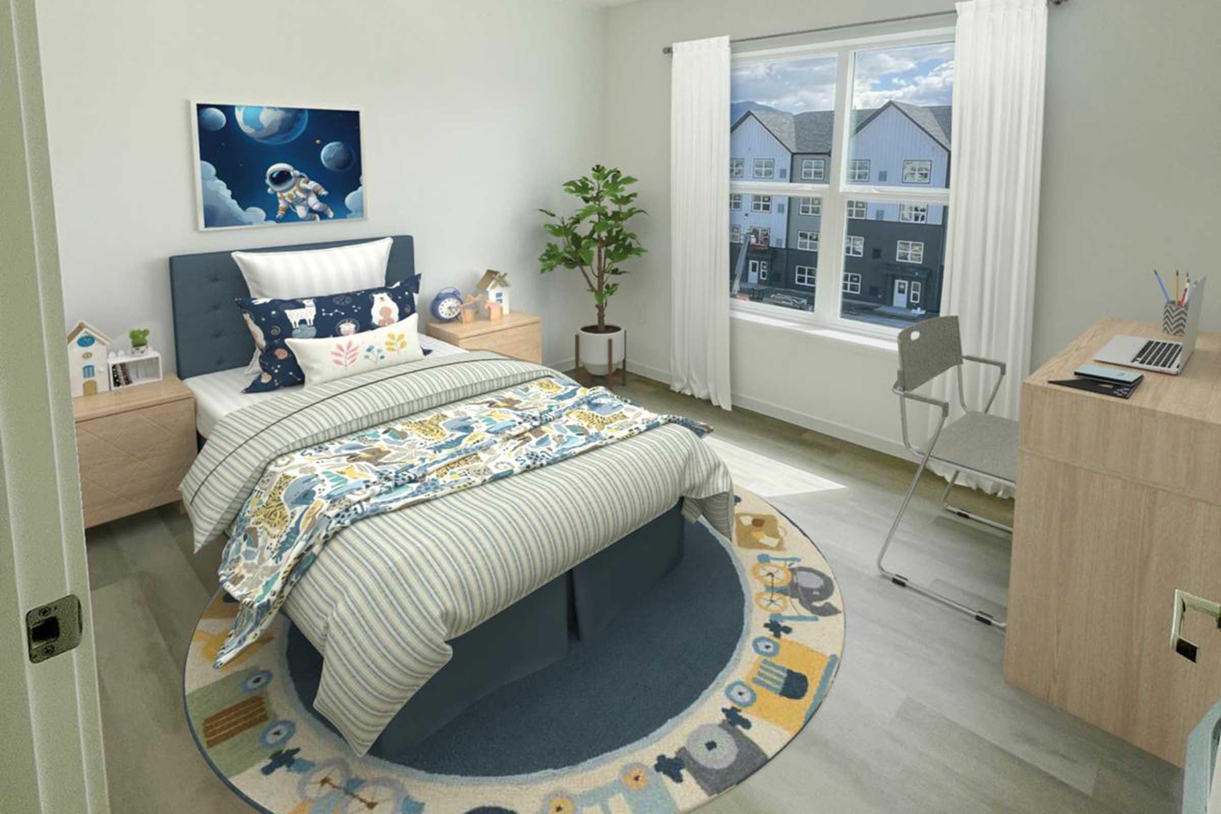 A cozy bedroom featuring a twin bed with a striped blanket, decorative pillows, and a space-themed wall art. There's a small desk with a chair, a potted plant, and a colorful round rug. Natural light streams in through a window, highlighting a modern aesthetic with neutral walls and wooden furniture.