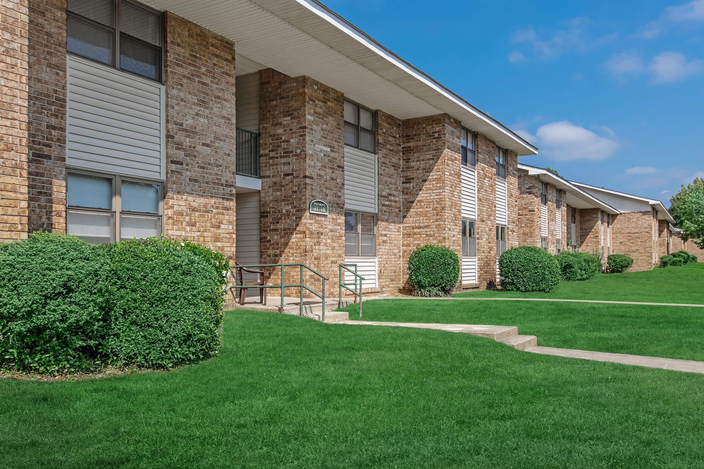 a large lawn in front of a brick building