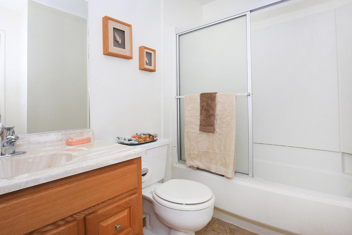 a white sink sitting next to a shower