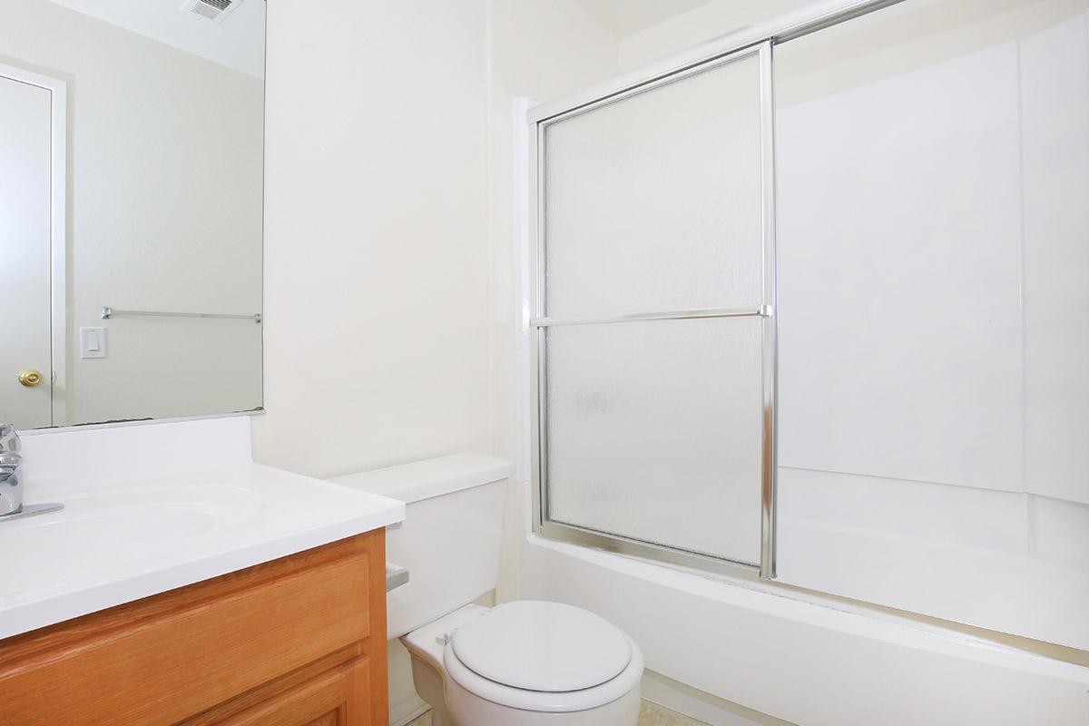 a white sink sitting next to a shower