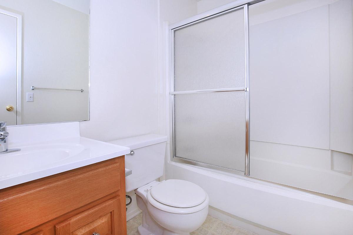 a white sink sitting next to a shower